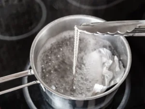 cleaning a silver necklace in a boiling, homemade silver cleaner