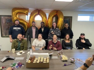 Ten members of the Garfield Refining team celebrate 500+ Google Reviews at their Philadelphia office.